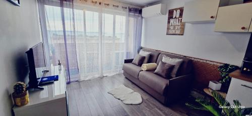 a living room with a couch and a large window at Studio 2 personnes Vue Mer Climatisé Linge Maison in Le Lavandou
