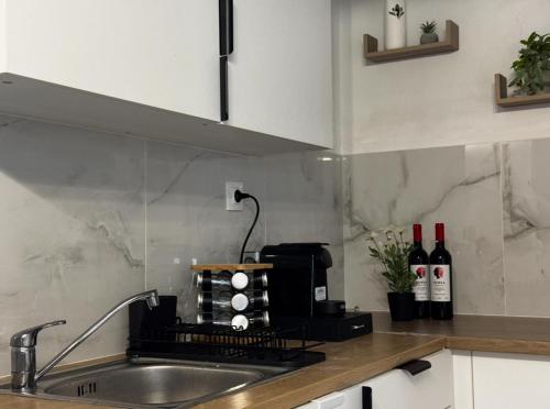una cucina con lavandino e bancone con bottiglie di vino di Giannis Philoxenia a Paloúkia