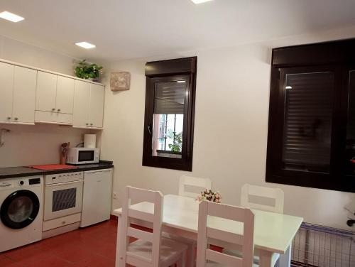 a kitchen with a white table and chairs and a microwave at CUARZO loft La Piedra de Najera in Nájera