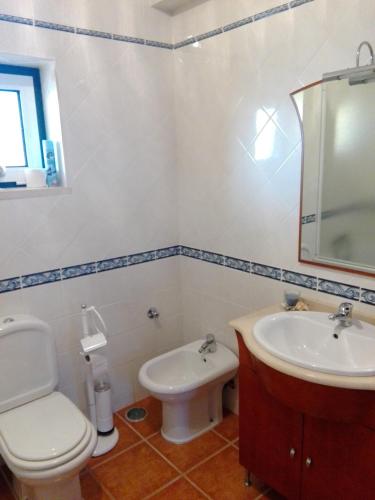 a bathroom with a toilet and a sink at Casa Monte Alegre in Redinha