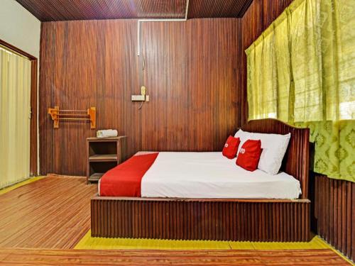 a bedroom with a bed with red pillows at OYO 90278 Redzwan's Beach Resort in Kota Bharu