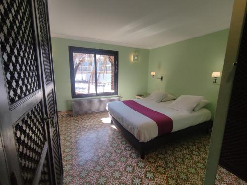 une chambre avec un grand lit avec une fenêtre dans l'établissement Chambre Emeraude, Riad 9 Couple only au village naturiste, au Cap d'Agde