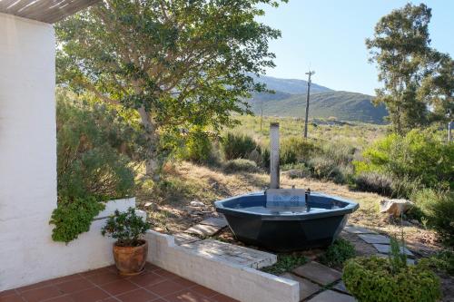 a bath tub sitting outside of a house at Kogman & Keisie Guest Farm in Montagu