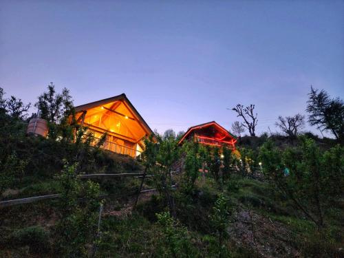 a house on a hill with lights on it at Mountain A Frame Stay Sainj in Sainj