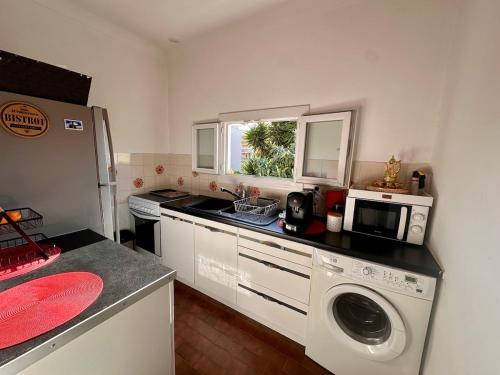 une cuisine avec un évier et une machine à laver dans l'établissement 2p calme, parking, proche centre, à Beaulieu-sur-Mer
