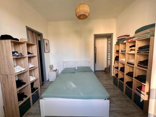 une chambre avec un lit et des étagères avec des chaussures dans l'établissement 2p calme, parking, proche centre, à Beaulieu-sur-Mer