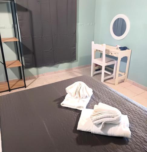 two towels on a bed with a table and a mirror at TheOldHouse Seaview in Corfu