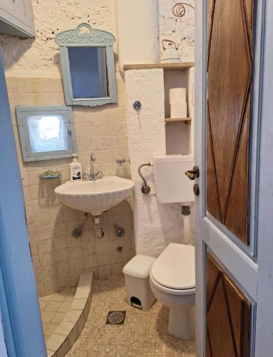 a small bathroom with a toilet and a sink at Windmill Studios in Livadi