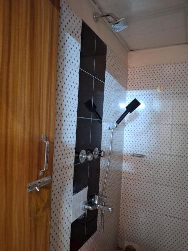 una doccia con una porta in vetro in un bagno di Hotel Dhanmondi a Dhaka