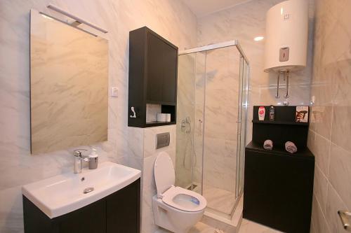a bathroom with a toilet and a sink and a shower at White Diamond in Palić