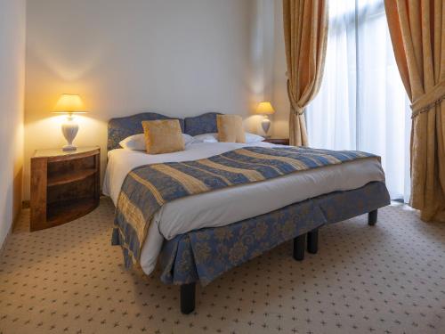 a bedroom with a bed with a blue and yellow blanket at Park Hotel Principe in Lugano