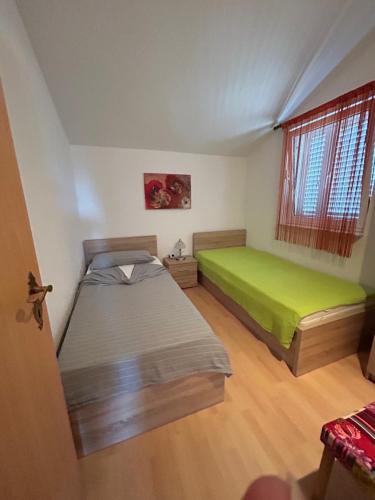 1 Schlafzimmer mit 2 Betten und einer grünen Matratze in der Unterkunft Apartment Maki with new Pool Nin in Vrsi