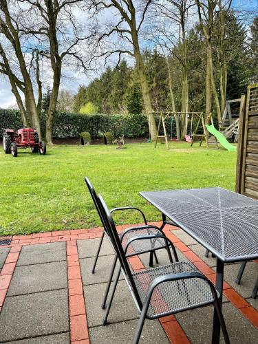 a table and chairs sitting on a patio with a playground at Ferienhof Westermann Waldblick in Lähden
