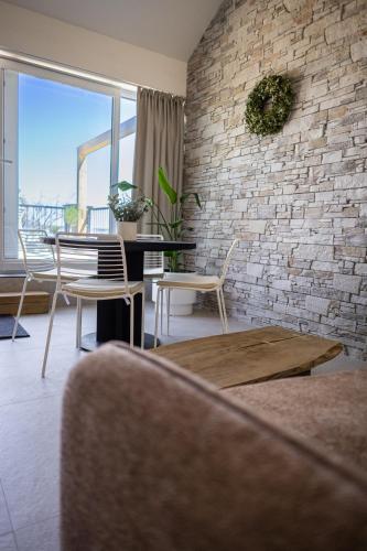 a living room with a brick wall and a table and chairs at Pálavské Apartmány Original in Pavlov