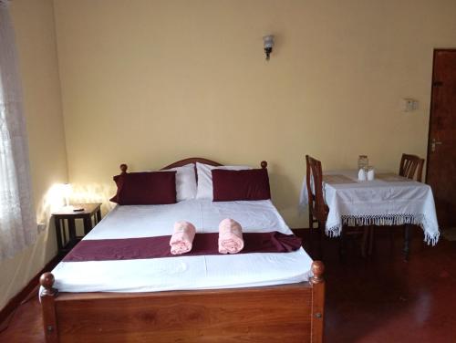 a bedroom with a bed with two pink slippers at Residence Balanagala View Kandy in Katugastota