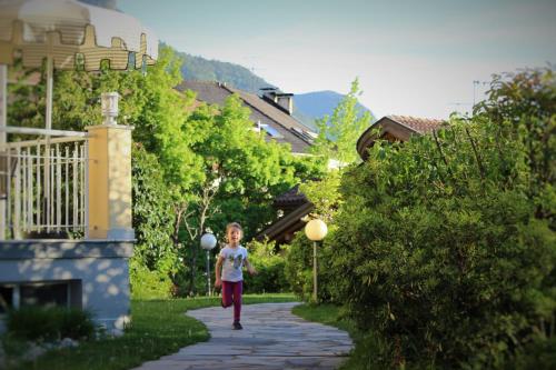 a little girl is walking down a sidewalk at Gartenresidence Stephanie by Hotel Rotwand in Laives