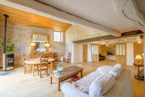 un salon avec un canapé blanc et une table dans l'établissement Ancien chai réthais restauré en 2020, à Sainte-Marie de Ré