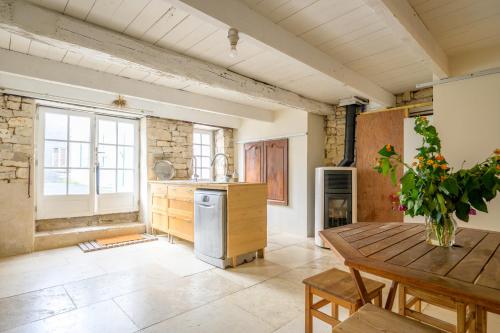 - une cuisine avec une table en bois et une table sidx sidx sidx dans l'établissement Ancien chai réthais restauré en 2020, à Sainte-Marie de Ré