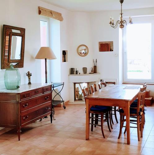 une salle à manger avec une table en bois et une commode dans l'établissement Résidence Keryvet, maison de charme vue mer, plage à 250m,, à Pleumeur-Bodou