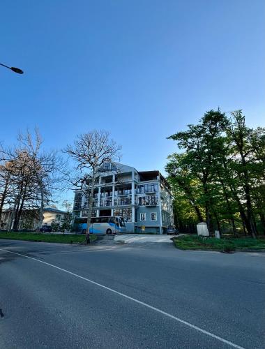 a large white building on the side of a street at Green Hotel Tskaltubo in Tskaltubo