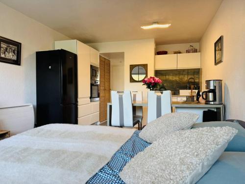 une chambre avec un grand lit et une cuisine dans l'établissement Ty Cardinaux, grand studio cabine, terrasse, jardin, tennis, à Quiberon