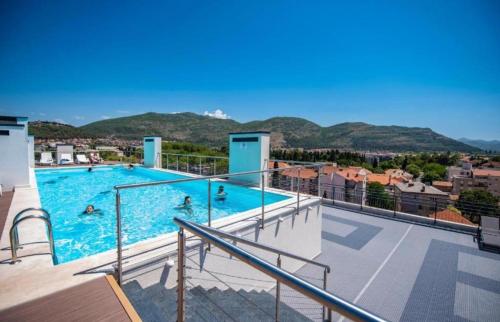 een groot zwembad met mensen in het water bij Apartman Agave in Trebinje