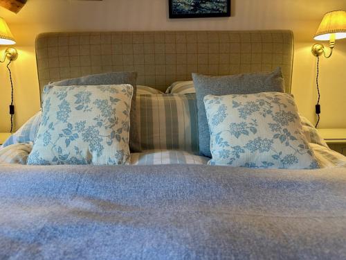 a bedroom with a bed with blue and white pillows at The Old Forge B&B and Glamping in Compton Abbas