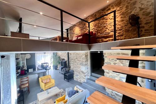 un grand salon avec un mur en pierre dans l'établissement Blondel - Saint Jean de Muzols, à Saint-Jean-de-Muzols