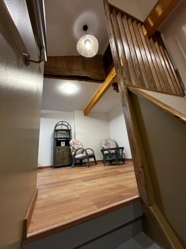Cette chambre dispose de parquet et de deux chaises. dans l'établissement La Petite Maison d'Elodie, à Saint-Alvère