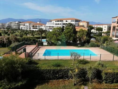 une grande piscine devant certains bâtiments dans l'établissement Escale aux tropiques - Vue mer, à Saint Cyprien Plage