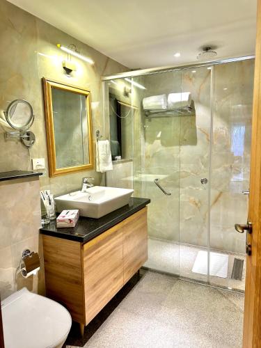 a bathroom with a sink and a shower at Eden Wellness and Hospitality in Dehradun