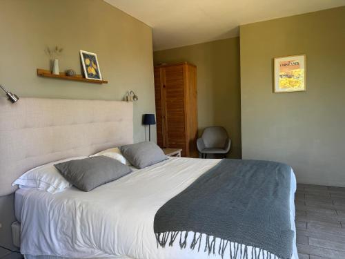 a bedroom with a large white bed with two pillows at Le Ruone in Calcatoggio