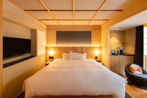 a hotel room with a large bed and a tv at Homm Stay Nagi Arashiyama Kyoto By Banyan Group in Kyoto