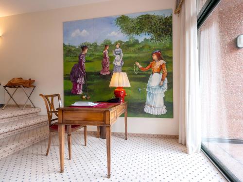 a painting of women on a wall next to a desk at Park Hotel Principe in Lugano