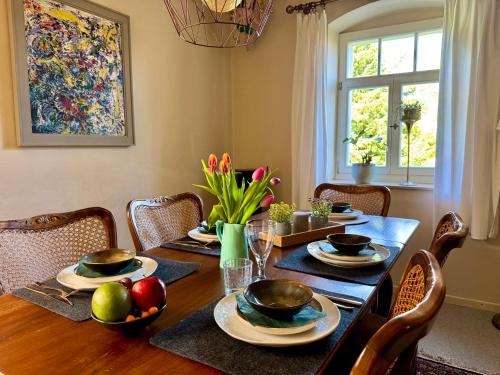 a dining room table with plates and bowls of fruit on it at Familienfreundliches Landhaus "Karin" mit Pool in Struppen