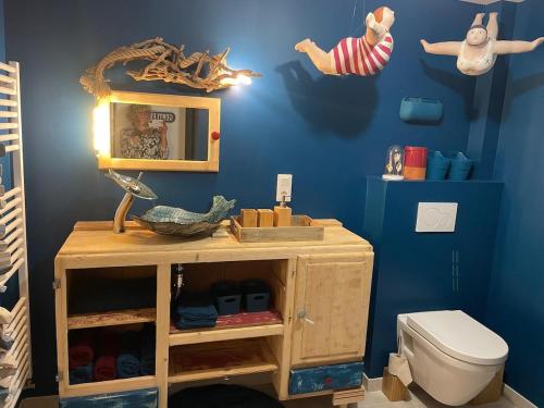 La salle de bains est pourvue d'une armoire en bois et de toilettes. dans l'établissement Les Collines d'Omaha, à Saint-Laurent-sur-Mer