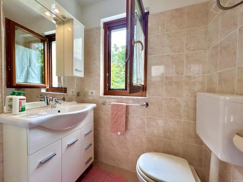 a bathroom with a sink and a toilet and a window at CASA NINNO BERTIGARo in Bertigaro