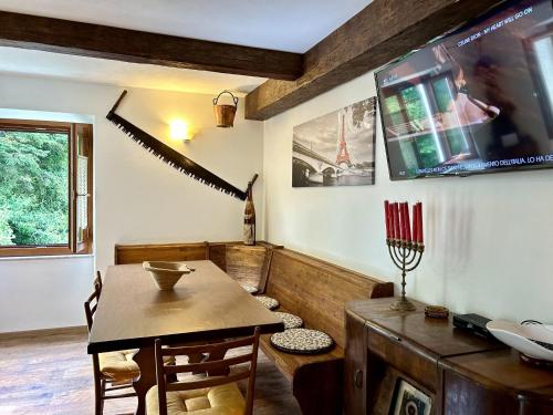 a dining room with a table and a tv at CASA NINNO BERTIGARo in Bertigaro
