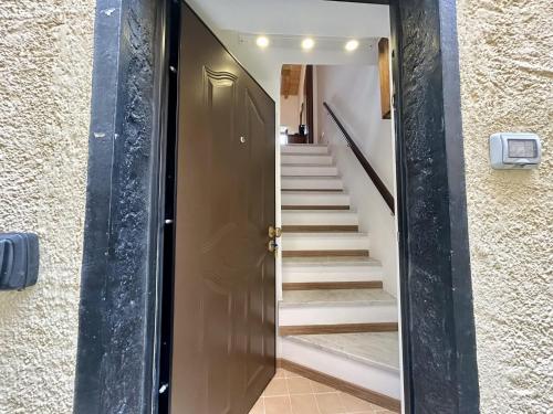 a hallway with a brown door and stairs at CASA NINNO BERTIGARo in Bertigaro