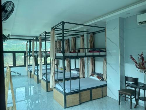 four bunk beds in a room with a desk at New Sun Hotel in Dồng Văn