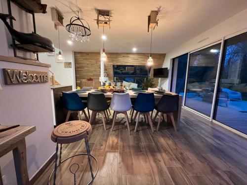une cuisine et une salle à manger avec une table et des chaises dans l'établissement Les Collines d'Omaha, à Saint-Laurent-sur-Mer