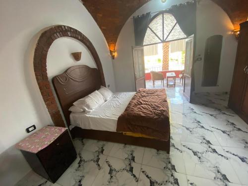 a bedroom with a bed in a room with a marble floor at Nur al Nil Garden House in Luxor