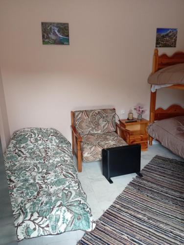 a bedroom with a bed and a chair and a pillow at Ξενώνας στα Θεοδώριανα 3 - Guesthouse Theodoriana 3 in Theodoriana