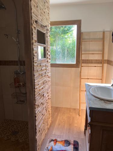 La salle de bains est pourvue d'un lavabo, d'une douche et d'un porte-parole. dans l'établissement Les Hauts d'Omaha, à Saint-Laurent-sur-Mer