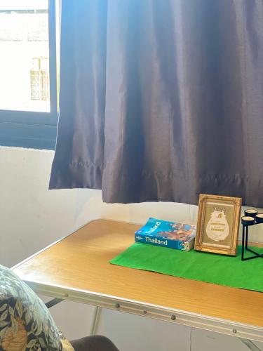 a table with a book on it next to a window at Nokhook House in Trang