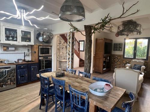 une cuisine et une salle à manger avec une table et des chaises en bois dans l'établissement Les Hauts d'Omaha, à Saint-Laurent-sur-Mer