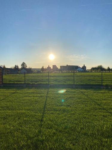 a sunset in a field with a ball in the grass at Dworek pod Krzyżtoporem Ujazd Agroturystyka- pokoje do wynajęcia in Iwaniska