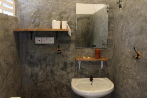 a bathroom with a sink and a mirror at The Stables Oceanfront Hotel Midigama in Midigama
