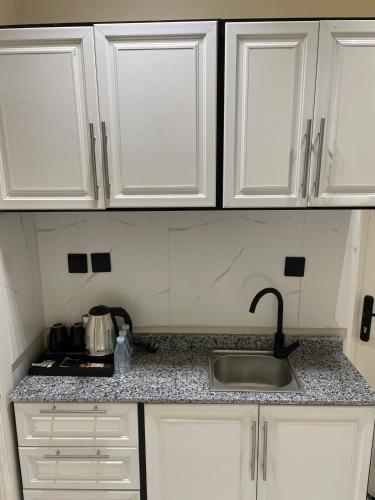 a kitchen with white cabinets and a sink at Studio in the resort Smart Entry in Quai