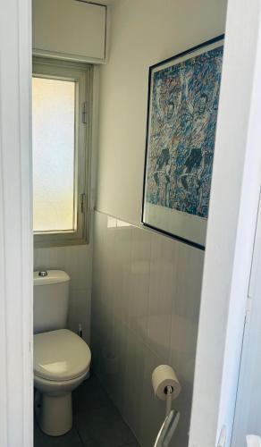 une salle de bain avec toilettes et un tableau au mur dans l'établissement Appartement Menton front de mer au dernier étage de 95M2 avec Terrasse de 70M2, à Roquebrune-Cap-Martin